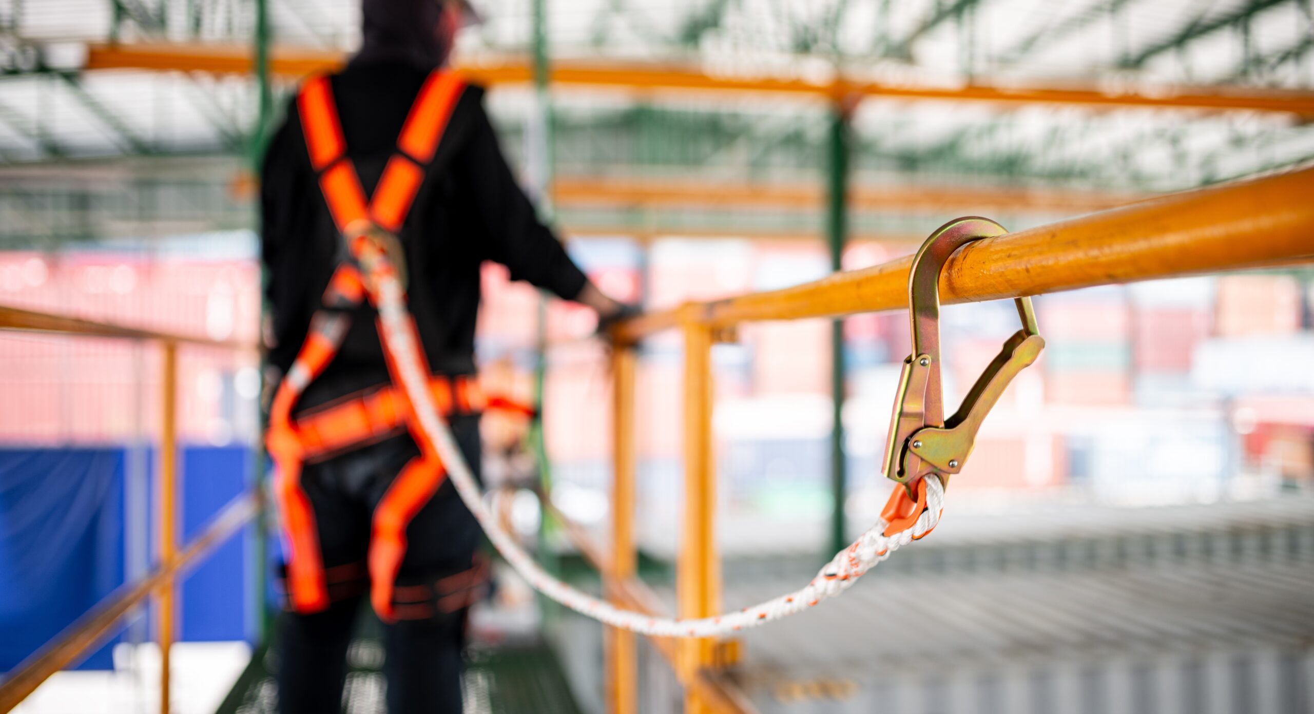 Construction worker wearing safety harness and safety line working at high place